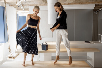 Wall Mural - Stylish female couple dancing together having fun during a party in the modern studio apartment. Homosexual relations and happy leisure time at home