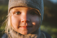 Child Girl Face Portrait Close Up Looking At Camera Cute Baby 2 Years Old Smiling Wearing Hat Outdoor