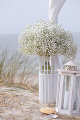 Wall Mural - Bohemian wedding bouquets , seashells and burning candle on sand by sea ​​coast