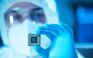 The scientist works in a modern scientific laboratory for the research and development of microelectronics and processors. Microprocessor manufacturing worker uses computer technology and equipment.