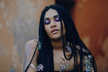 Portrait of a young beautiful tattooed girl with box braids hairstyle