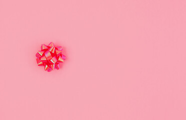 Pink gift bow on a pink background. Gift wrapping.