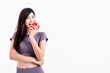 © Anatta_Tan - Portrait images of Asian attractive woman is good shape, holding and eating a red vegetable, bell pepper, On white background, concept to weight loss woman and health care concept.