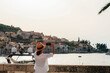 Girl tourist photographs the sea bay and buildings in Korcula town, Croatia