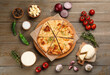 © New Africa - Delicious khachapuri with cheese, sauce, vegetables and spices on wooden table, flat lay