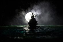 Silhouettes Of A Crowd Standing At Blurred Military War Ship On Foggy Background. Selective Focus.