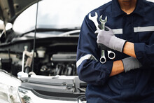 Hand Of Car Mechanic With Wrench. Auto Repair Garage. Mechanic Works On The Engine Of The Car In The Garage. Repair Service. Concept Of Car Inspection Service And Car Repair Service.