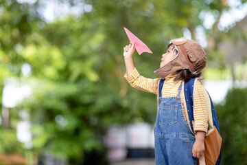 Happy Asian kid playing with a paper airplane