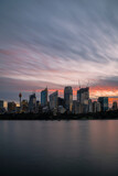 Fototapeta  - Sunset illuminating the wispy clouds in the sky above the Sydney city skyline