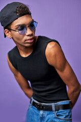 Wall Mural - Latino transgender model in casual pose close up portrait. Muscular male in cap, t-shirt with glasses