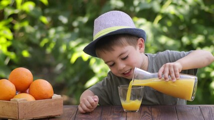 Wall Mural - little independent boy pouring fresh orange juice into glass