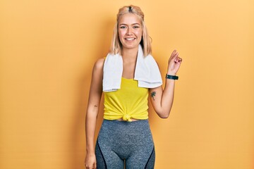 Sticker - Beautiful blonde sports woman wearing workout outfit with a big smile on face, pointing with hand finger to the side looking at the camera.