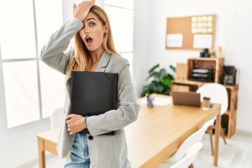 Poster - Blonde business woman at the office surprised with hand on head for mistake, remember error. forgot, bad memory concept.