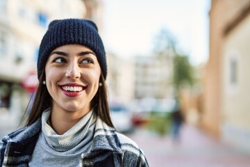 Wall Mural - Young hispanic woman smiling happy standing at the city.