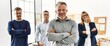 © Krakenimages.com - Middle age businessman smiling with arms crossed gesture standing with work partners at the office.