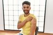 © Krakenimages.com - Arab young man getting vaccine showing arm with band aid looking positive and happy standing and smiling with a confident smile showing teeth