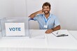 © Krakenimages.com - Young handsome man at political election sitting by ballot smiling doing phone gesture with hand and fingers like talking on the telephone. communicating concepts.