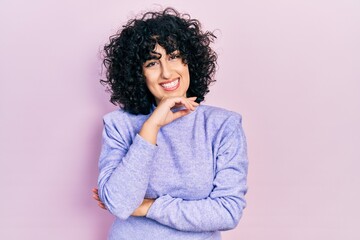 Sticker - Young middle east woman wearing casual clothes looking confident at the camera with smile with crossed arms and hand raised on chin. thinking positive.