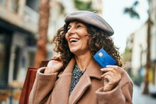 Middle Age Hispanic Woman Shopping Holding Credit Card At The City.