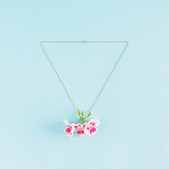 Wall Mural - Creative idea of necklace and pink blooming flowers as pendant. Minimal .jewelry flat lay concept.