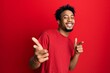 © Krakenimages.com - Young african american man with beard wearing casual red t shirt pointing fingers to camera with happy and funny face. good energy and vibes.