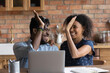 © fizkes - Happy excited Black mixed race couple celebrating financial success at laptop, getting income, loan, mortgage bank approval, planning good family budget. Young husband and wife giving high five