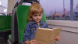© Andrii Iemelianenko - Portrait of attractive young little child girl sitting at empty subway train, reading interesting book. Concept of people, literature, public transport. Kid passenger traveling at modern tram or bus