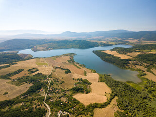 Wall Mural - Aerial view of a blue lake, agricultural fields and mountains under a blue clear sky