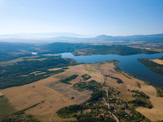 Wall Mural - Aerial view of a blue lake, agricultural fields and mountains under a blue clear sky