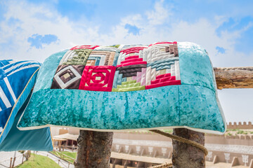 Asian national bed linen velvet pillows are dried on a fence in the sun.