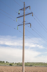 High-voltage concrete electric pole with wires on the background of the sky.