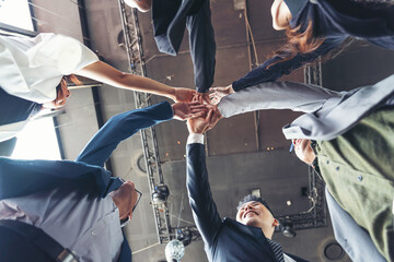 Wall Mural - Group of diverse businesspeople holding hands together. Business team or business partners join hands together. business, people, investment concept