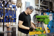 © Maria Sbytova - Metalwork craftsman working with metal at workshop. Master using drilling machine. Diy. Small local business.