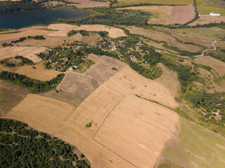 Sticker - Aerial view of a lake, surrounded by agricultural fields, buildings and dense trees