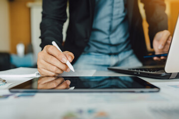 Young businessman working at home office living spaces for investment analyzing company financial report balance with laptop computer and smart phone. Concept for stock market, tax, and project