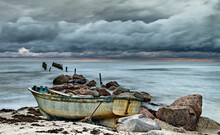 Coastal Landscape With Broken Abandoned  Pier And Beached Old Fishing Boat After Autumnal Storm, Baltic Sea