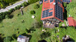 Luftaufnahme Einfamilienhaus mit Garten Balkon und Photovoltaikanlage udn Menschen