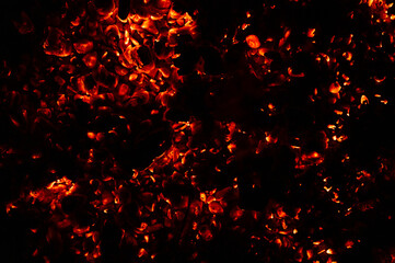 background of burning and glowing hot coals. smoldering embers of fire. flicker of burning coals at night