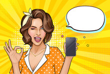Pop Art Girl Holding Mobile Phone. Winking Woman Showing Screen Of New Smartphone And OK Sign. Pretty Lady On Yellow Background With Empty Speech Bubble. Vector Illustration For Digital Advertisement.