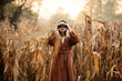 Style woman with binoculars on corn field in autumn time season