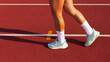 female legs in sports sneakers step on the stadium running track. sports training and exercise, healthy lifestyle.