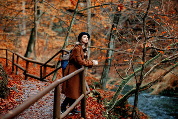 Sticker - Young woman with cup of coffee in an autumn season park