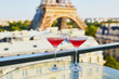 © Ekaterina Pokrovsky - Two Cosmopolitan cocktails in traditional martini glasses with view to the Eiffel tower, Paris, France