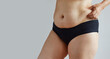 © evafesenuk - Side view of a full mature woman, slightly overweight, hand on belly. Studio shot on gray background
