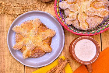 traditional mexican pan de muerto with hot chocolate and cinnamon sticks. Bread to celebrate the day of the dead. Mexican celebration. top view