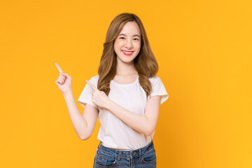 Wall Mural - Studio shot of cheerful beautiful Asian woman in white t-shirt and stand on yellow background.