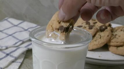 Wall Mural - Dunking a chocolate chip cookie into a glass of milk, variable speed
