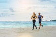 © Panumas - Couple runner jogging athletes at the beach with cloudy sky.