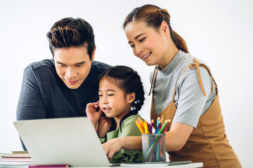 Portrait enjoy happy smiling love asian family father and mother with little asian girl learning and looking at laptop computer studying with online education e-learning system with teacher at home