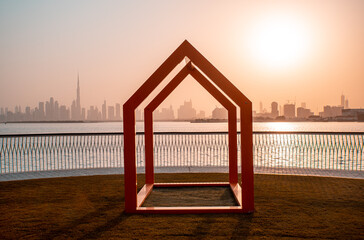 Wall Mural - Orange frame houses at the Dubai Creek Harbour waterfront with setting sun and the Dubai skyline in the background at golden hour